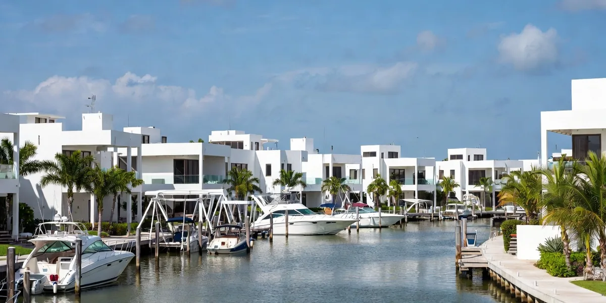 Modern canal-front homes with private docks and boats in a Cancún residential marina