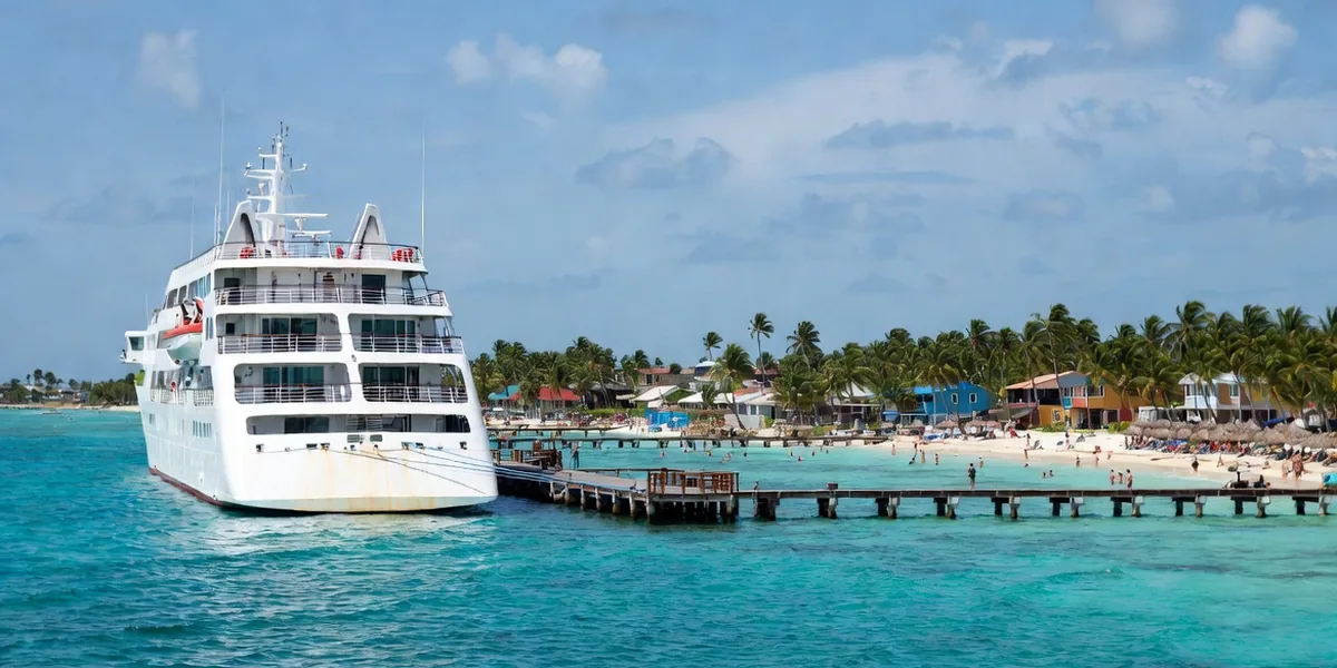 Cruise ship docked at the Costa Maya pier with the palm-lined Mahahual coastline stretching south