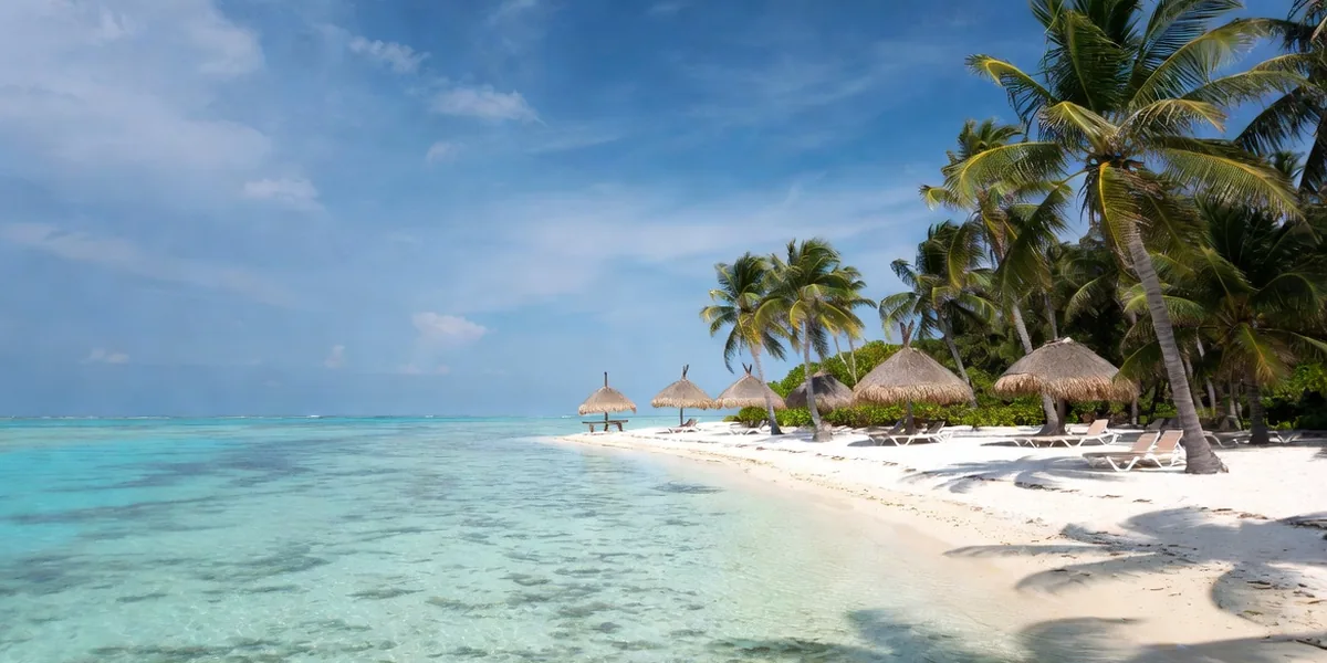 Calm turquoise water, white sand and palapas at Playa Palancar on Cozumel's west coast