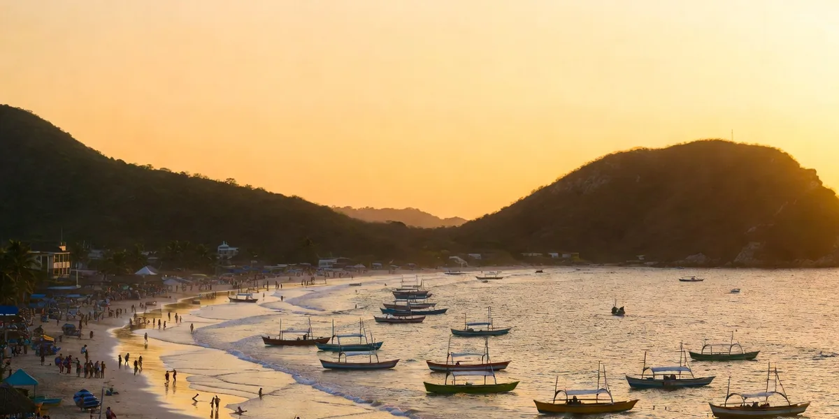 Zihuatanejo Bay at golden hour with fishing pangas anchored off Playa La Ropa and green headlands behind