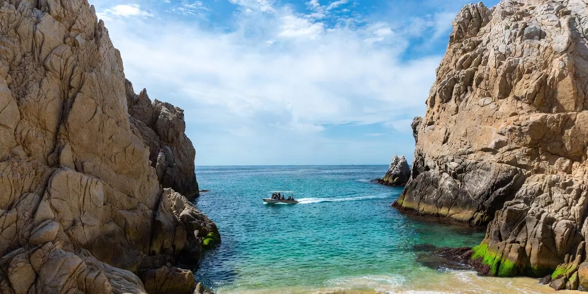 Lover's Beach between the granite rock formations of Land's End with a water taxi arriving, Cabo San Lucas