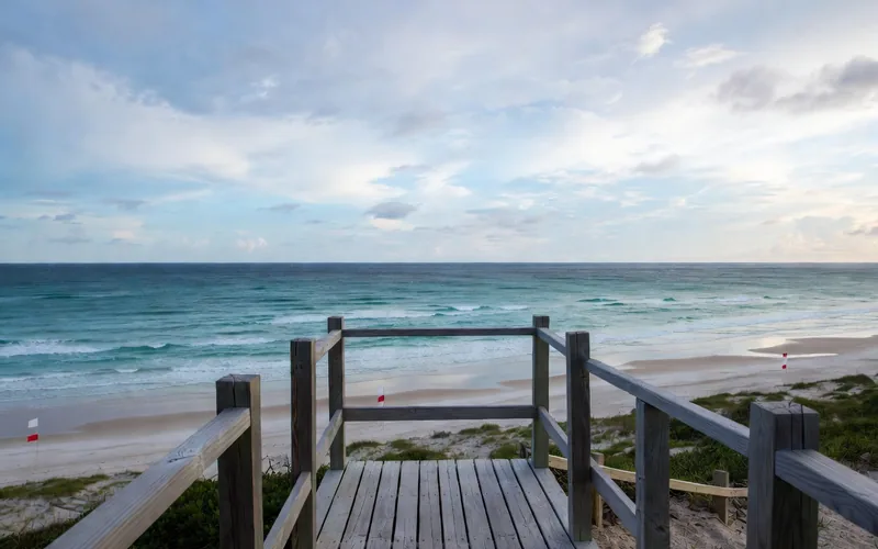 Wooden viewpoint over the beach and surf flags at Playa Delfines, Cancún